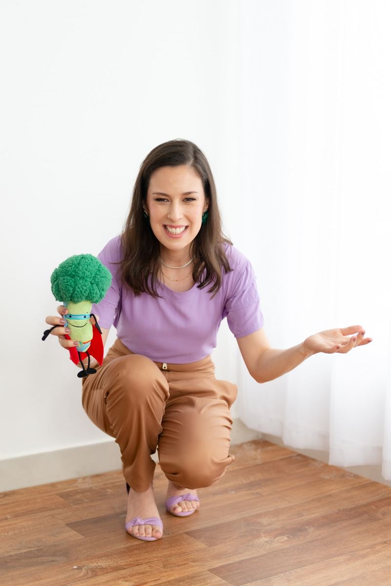 Lilianne Valente com um brinquedo de legumes